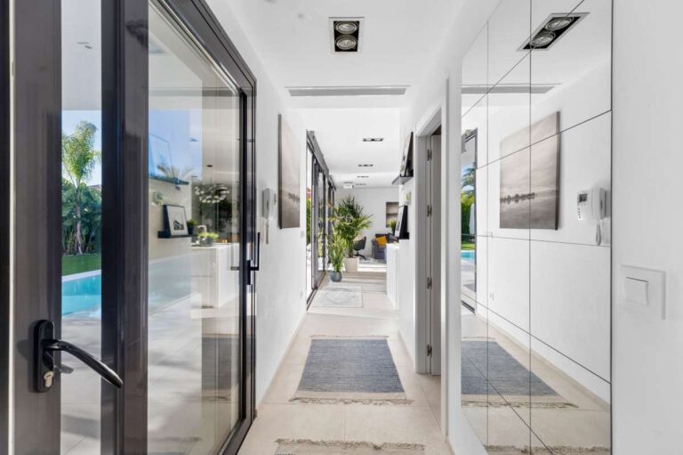 Interior hallway with glass doors and garden views inside a modern oasis villa for sale in Calpe.