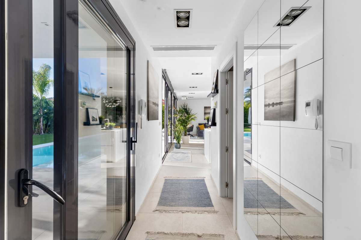 Interior hallway with glass doors and garden views inside a modern oasis villa for sale in Calpe.