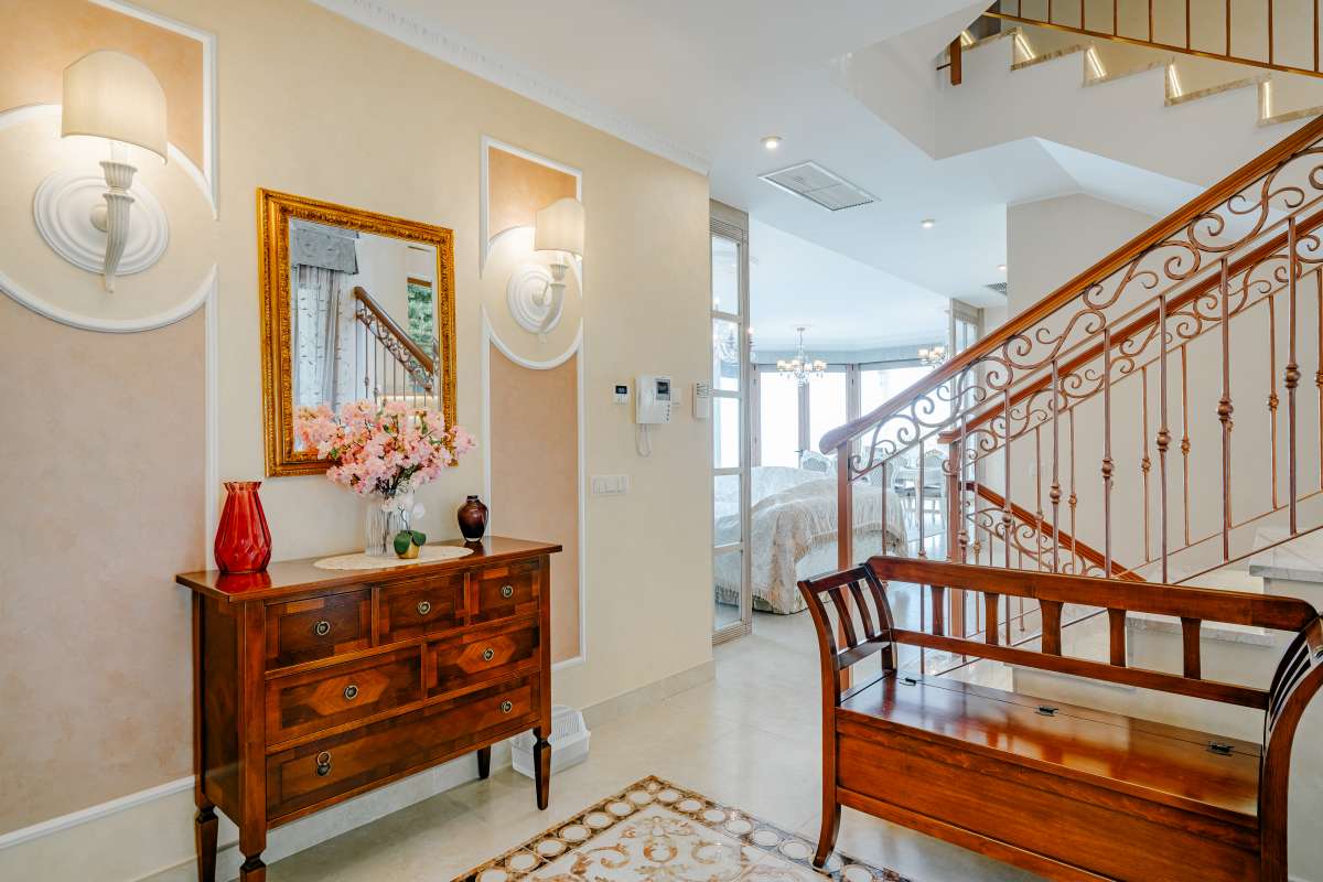 Interior hallway with staircase, wooden detailing and natural light inside a frontline villa in Les Bassetes.