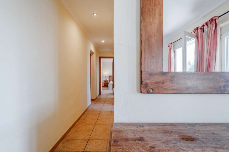 Interior hallway with traditional wooden mirror and tiled floor inside a Mediterranean villa with guest accommodation in Calpe.