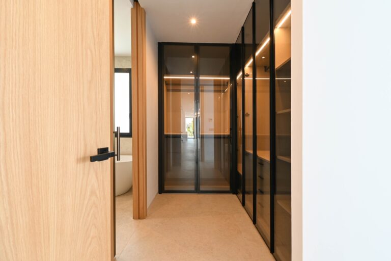 Interior hallway with wood and glass finishes at luxury villa near La Fustera Beach