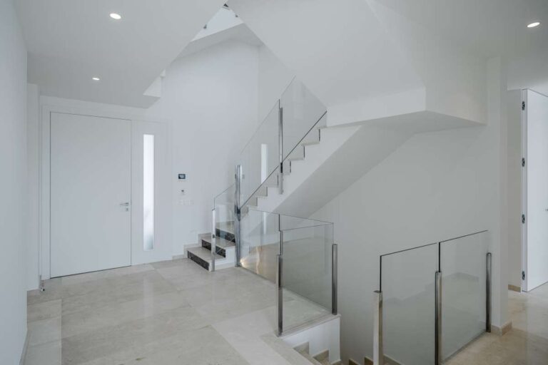 Interior staircase and hallway inside a modern second-line sea villa in La Calalga, Calpe with glass balustrade and bright contemporary finish