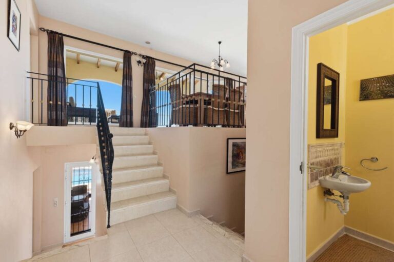 Interior staircase inside an elegant Mediterranean villa in Altea Hills with split-level layout, railings and bright hallway space