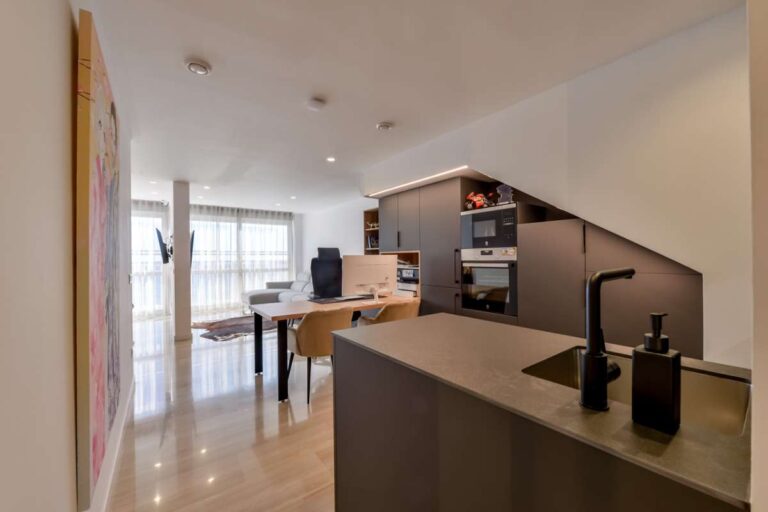 Kitchen and dining area inside a luxury frontline beach duplex in Mascarat, Altea with island, dining table, modern cabinetry and bright interior