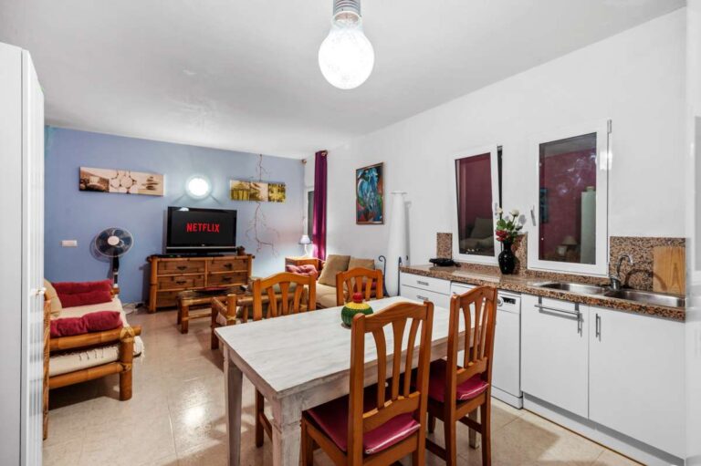 Kitchen and dining area inside an independent apartment of a Benissa sea view villa with white cabinetry, dining table and lounge area