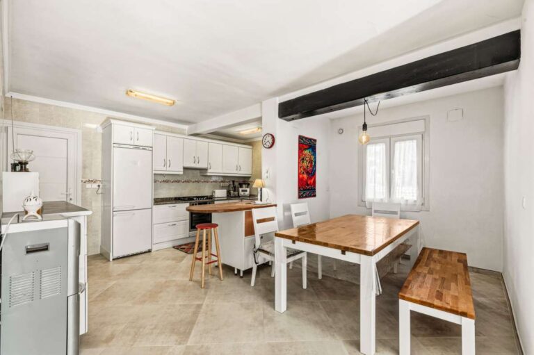 Kitchen and dining area with breakfast bar inside a contemporary villa in Calpe with private pool.