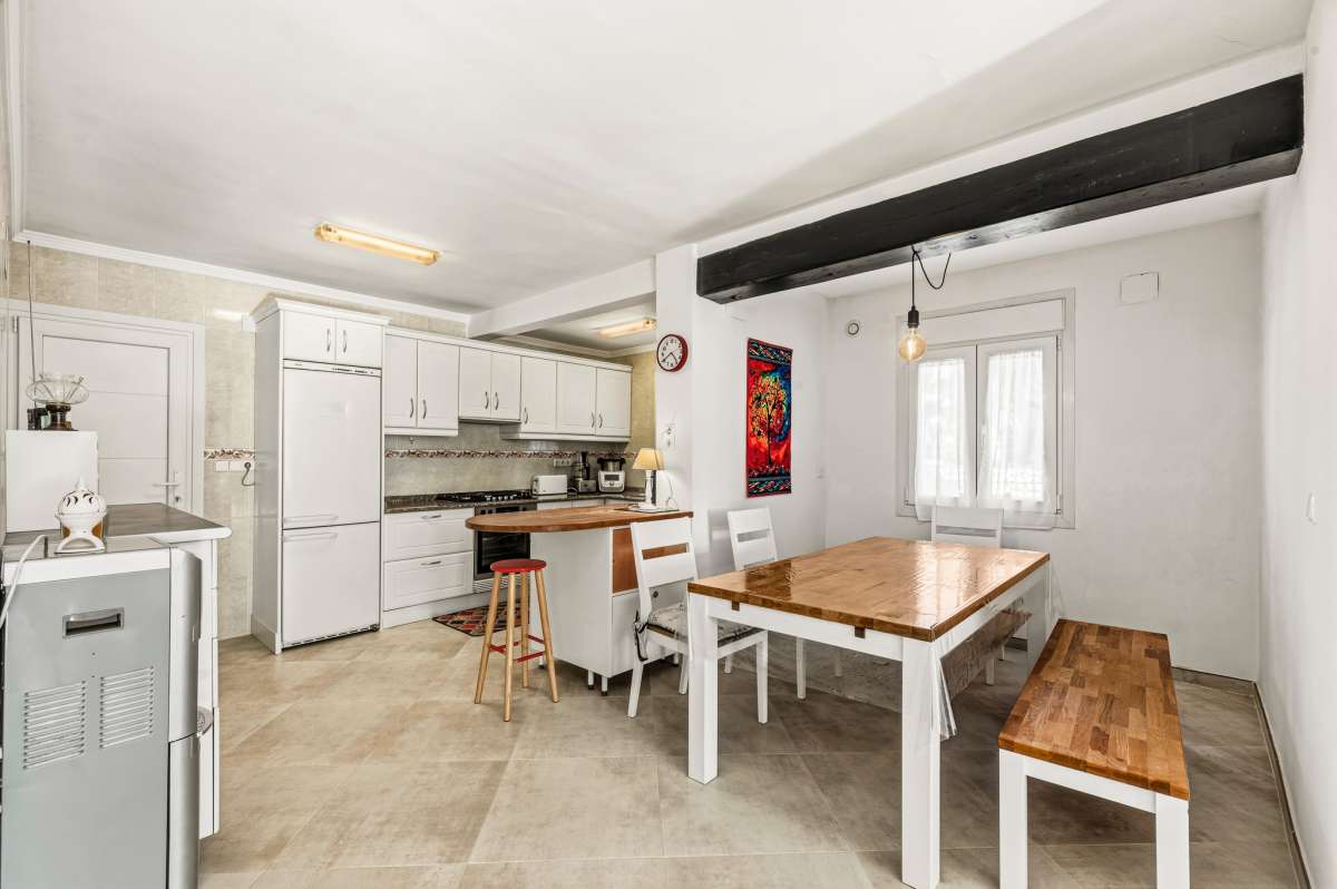 Kitchen and dining area with breakfast bar inside a contemporary villa in Calpe with private pool.