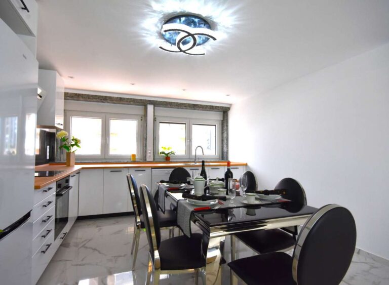 Kitchen and dining area with large windows inside a frontline double penthouse for sale on Arenal Beach in Calpe.