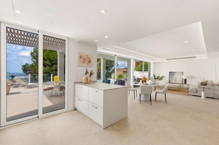 Kitchen and living area inside a modern villa in Altea Hills with terrace access, open-plan layout, large windows and natural light