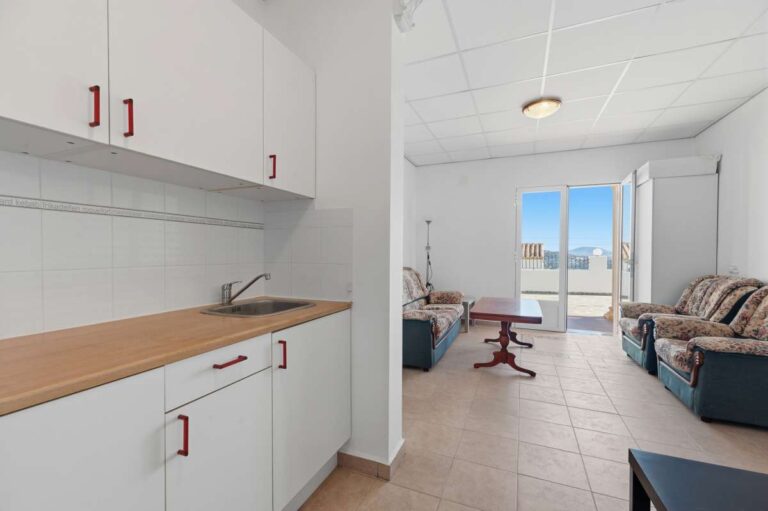 Kitchen and living area with fitted cabinets and natural light inside a villa in Calpe.