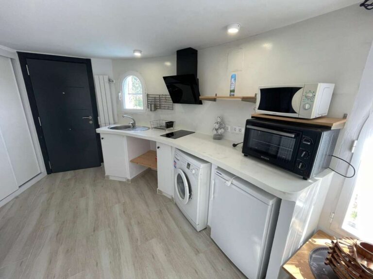 Kitchen and utility area with washing machine and fitted units inside a refurbished villa in Canuta, Calpe.