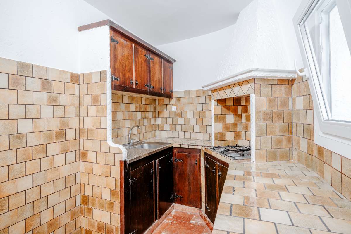 Kitchen detail with tiled worktops, wooden cabinetry and natural light inside a Mediterranean villa in Maryvilla, Calpe.