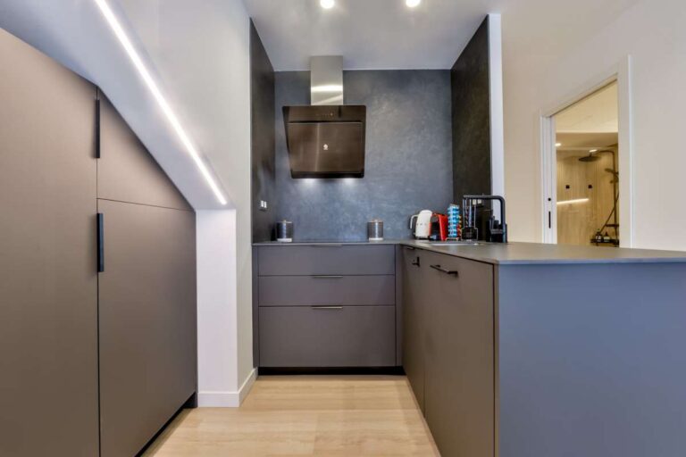 Kitchen inside a luxury frontline beach duplex in Mascarat, Altea with island, integrated appliances, hallway access and modern cabinetry