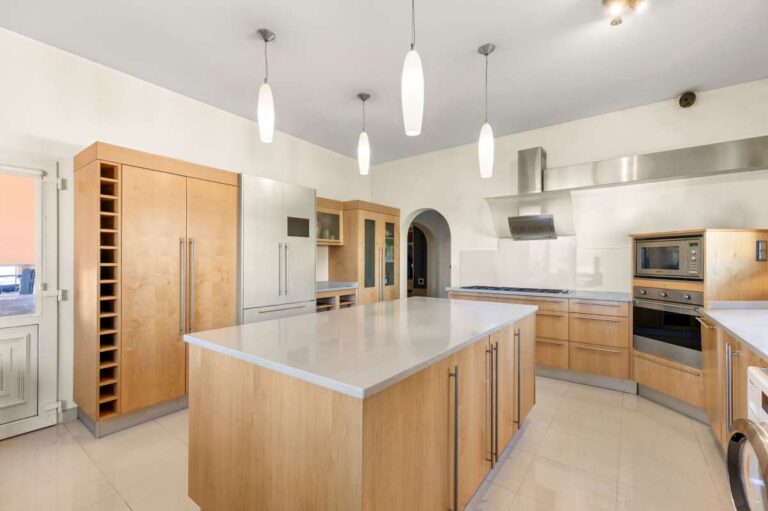 Kitchen inside a private Calpe villa with central island, wooden cabinetry, fitted appliances and wine storage