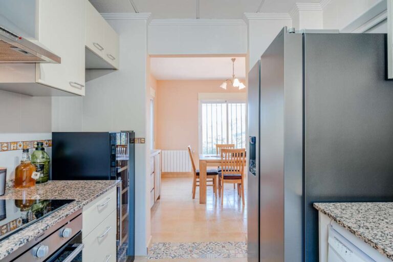 Kitchen inside a semi-detached house in Calpe with fitted appliances and access towards the dining area