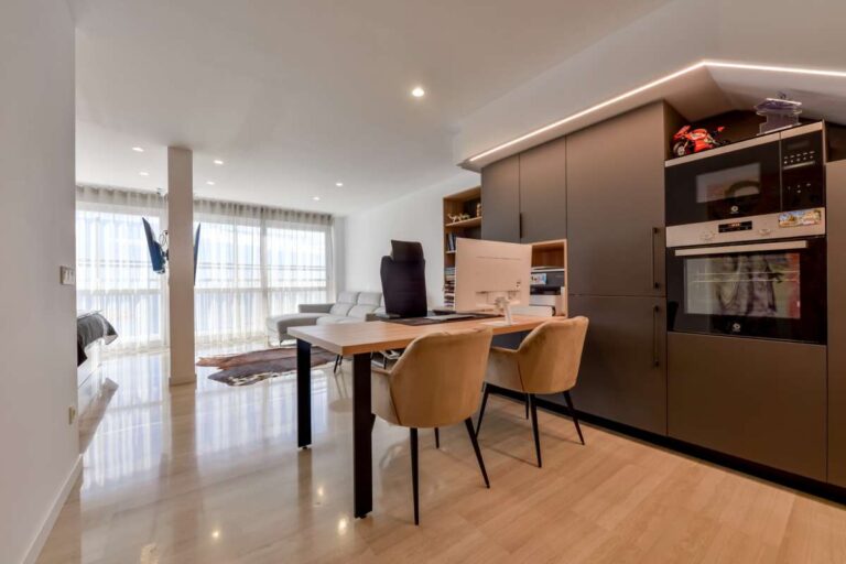 Kitchen island and dining area inside a luxury frontline beach duplex in Mascarat, Altea with integrated appliances, dining table and open-plan layout