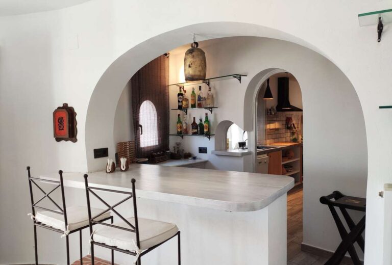 Kitchen with breakfast area and arched opening inside a refurbished villa with sea views in Canuta, Calpe.
