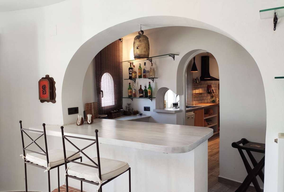 Kitchen with breakfast area and arched opening inside a refurbished villa with sea views in Canuta, Calpe.