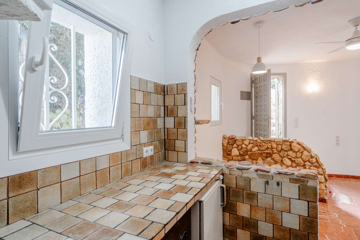 Kitchen worktop detail with tiled walls and stone feature elements inside a Mediterranean villa in Maryvilla, Calpe.