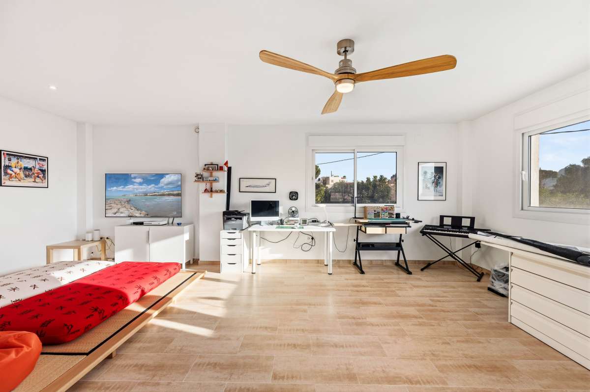 Large adaptable upper floor with natural light, ceiling fan and open space inside a contemporary villa in Calpe.
