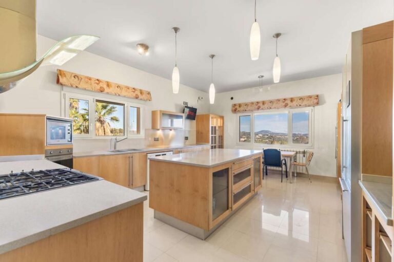 Large kitchen inside a private villa in Calpe with central island, fitted appliances, breakfast area and natural light
