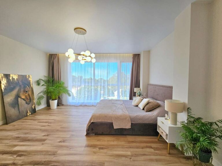 Large main bedroom inside a modern villa near Les Bassetes in Calpe with natural light, wood flooring and spacious layout