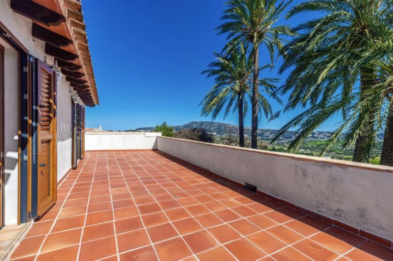 Large upper terrace at a traditional Spanish finca near Moraira with tiled flooring, palm tree, countryside views and open outdoor space