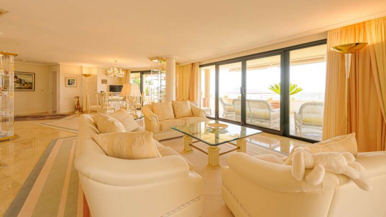 Living and dining area inside a luxury apartment in Sierra de Altea with marble flooring, sofa seating, terrace access and natural light