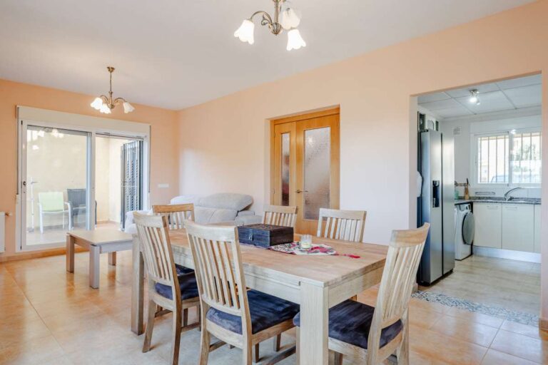 Living and dining area inside a semi-detached house in Calpe with terrace access, fitted kitchen and natural light