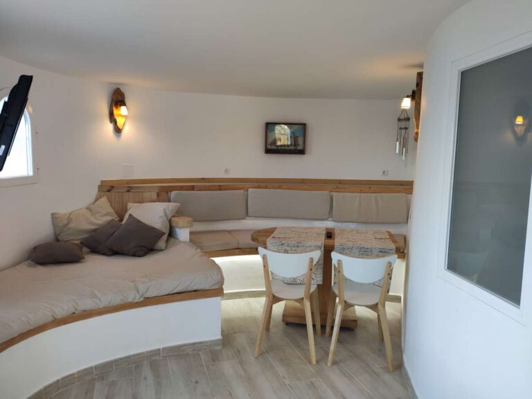 Living and dining area with curved seating and natural light inside a refurbished villa in Canuta, Calpe.