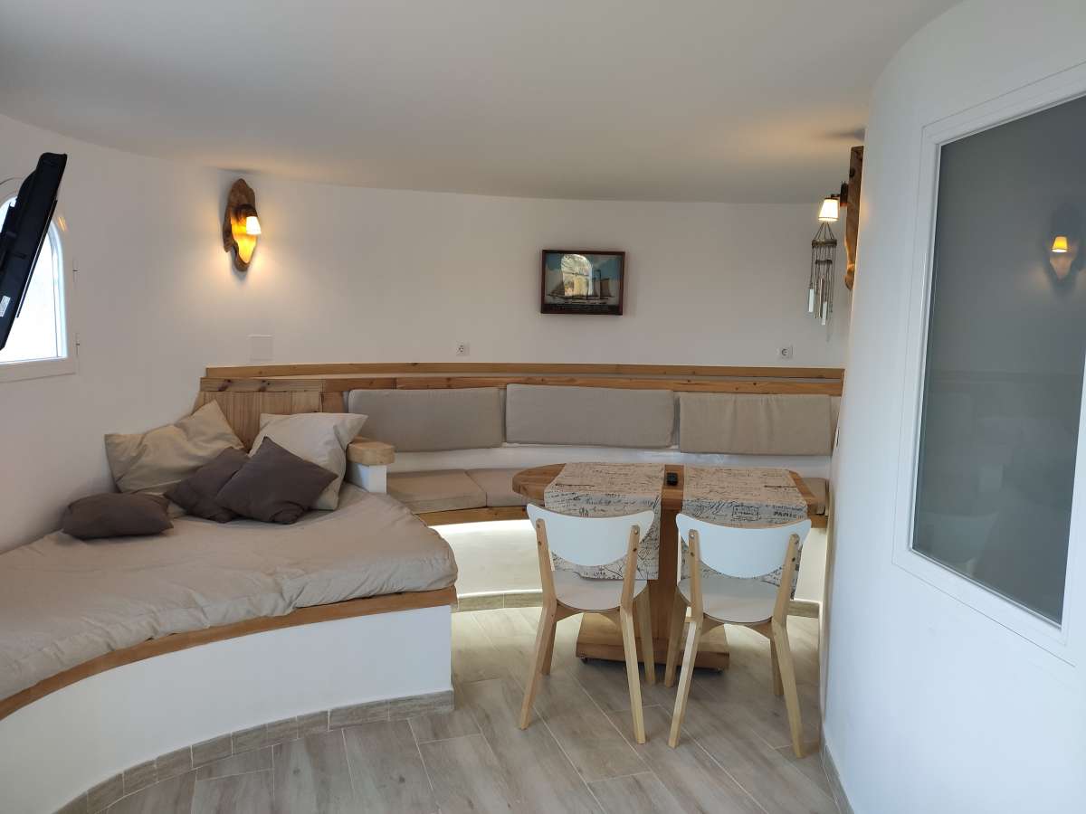 Living and dining area with curved seating and natural light inside a refurbished villa in Canuta, Calpe.