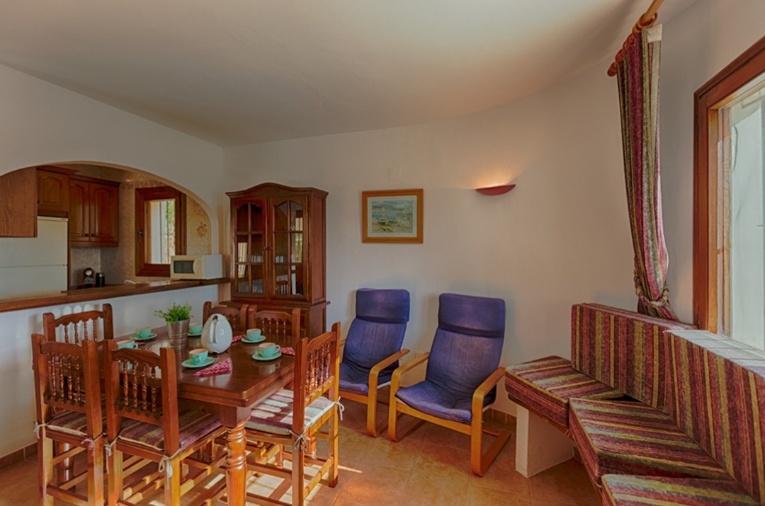 Living and dining area with traditional furniture and natural light inside a Mediterranean villa in Calpe.