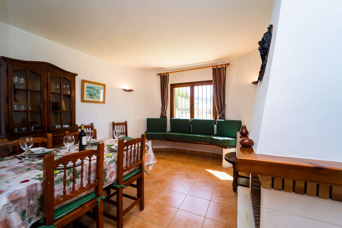 Living and dining room with traditional furniture, natural light and warm interior tones inside a Mediterranean villa in Calpe.