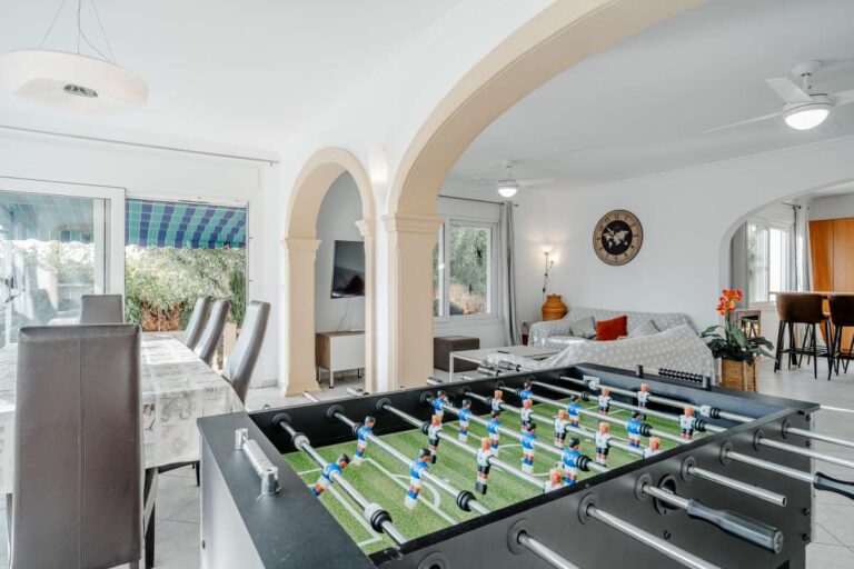 Living area in a Calpe villa with table football, arched openings and access to the dining space