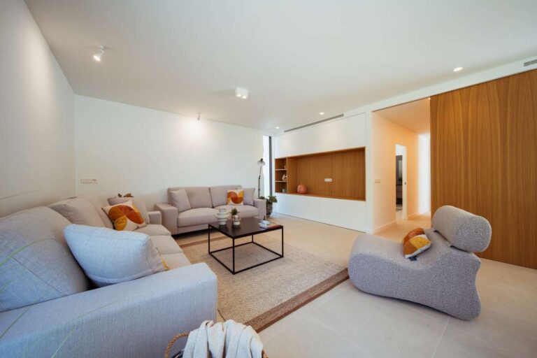 Living area inside a new-build luxury villa in Moraira with modern seating, wood feature wall and bright open-plan interior