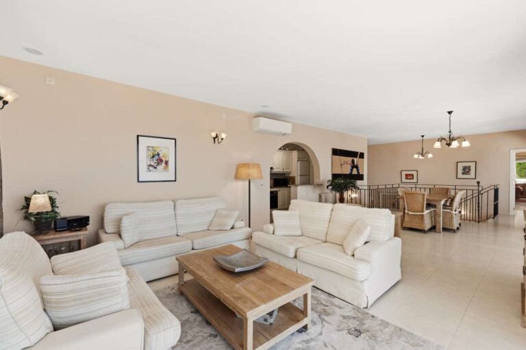 Living area inside an elegant Mediterranean villa in Altea Hills with sofa seating, open-plan dining space and bright neutral interior