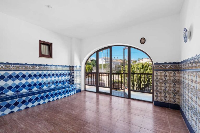 Living area with arched window and tiled finishes inside a guest apartment at a spacious villa in Calpe.