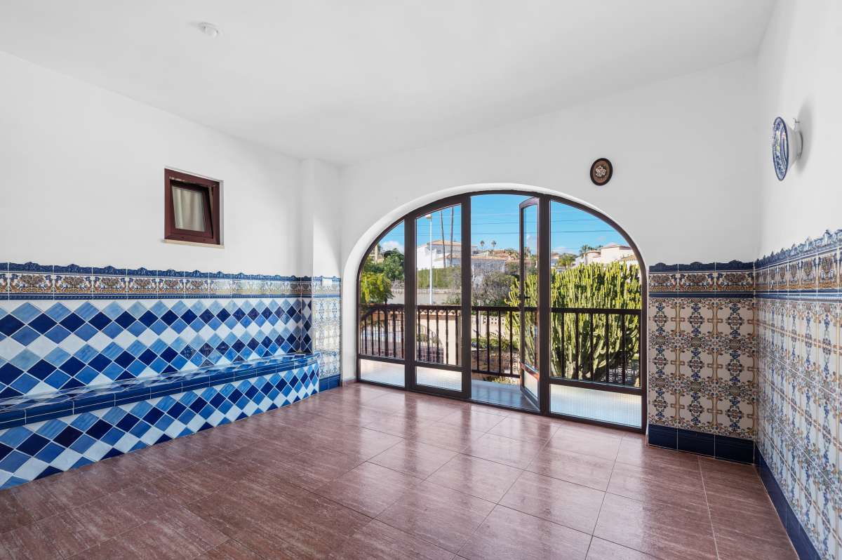 Living area with arched window and tiled finishes inside a guest apartment at a spacious villa in Calpe.