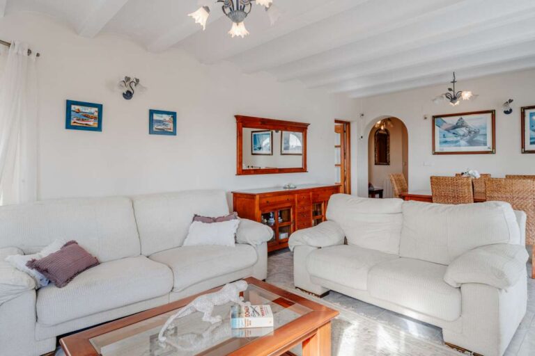 Living area with sofa seating, traditional furniture and arched doorway inside a Mediterranean villa in Calpe.