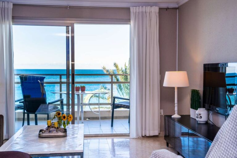 Living room inside a beachfront apartment by La Fossa Beach in Calpe with terrace access, TV area and Mediterranean Sea views