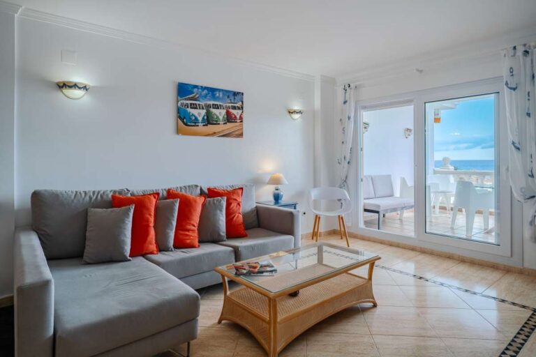 Living room inside a duplex apartment near Les Platgetes Beach in Moraira with sofa seating, terrace access, sea views and natural light