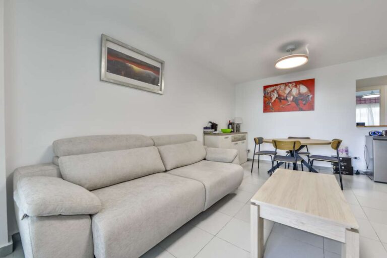 Living room inside a frontline La Fossa apartment in Calpe with sofa seating, dining area and bright interior