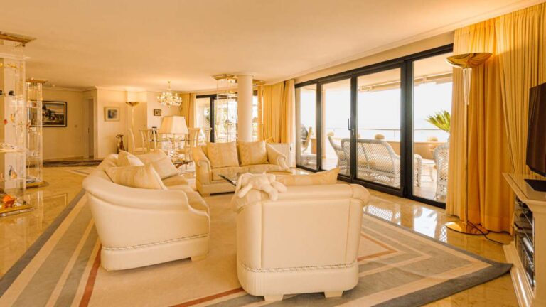 Living room inside a luxury apartment in Sierra de Altea with marble flooring, sofa seating, large sliding doors and access to the terrace