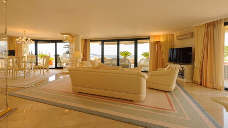 Living room inside a luxury apartment in Sierra de Altea with sofa seating, marble flooring, large windows, terrace access and panoramic views