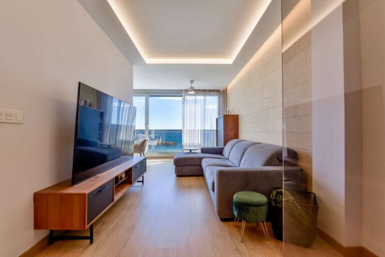 Living room inside a luxury frontline beach duplex in Mascarat, Altea with sofa seating, TV area, modern lighting and Mediterranean Sea views