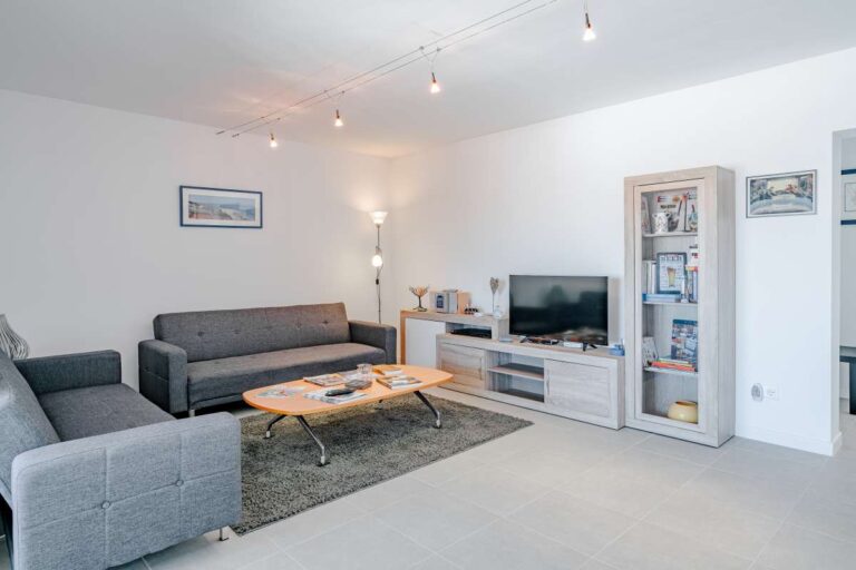 Living room inside a modern villa for sale in Calpe with sofa seating, TV unit and bright interior