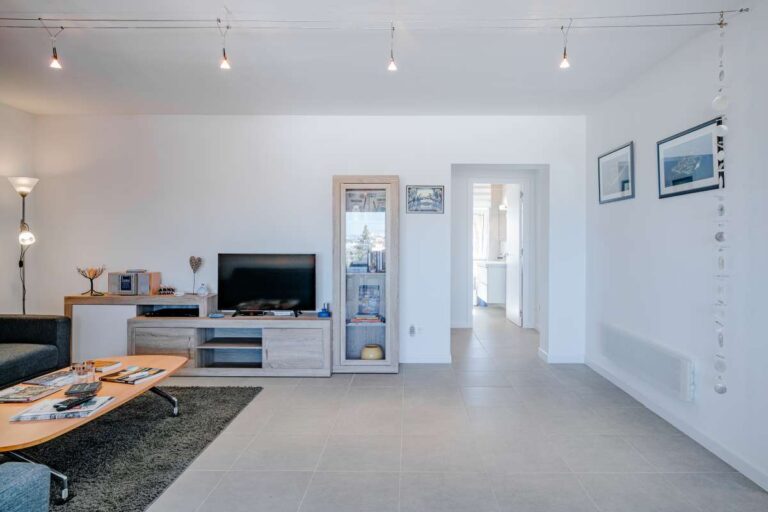 Living room inside a modern villa for sale in Calpe with TV area, tiled floor and bright open layout