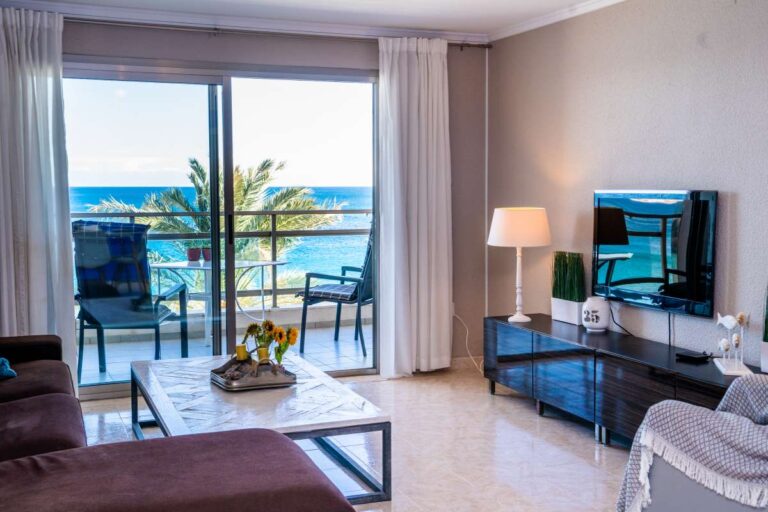 Living room inside a renovated La Fossa Beach apartment in Calpe with TV area, natural light and beachfront terrace views