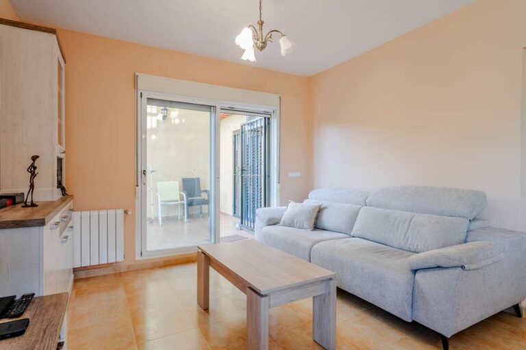 Living room inside a semi-detached house in Calpe with sofa seating, natural light and access to the terrace