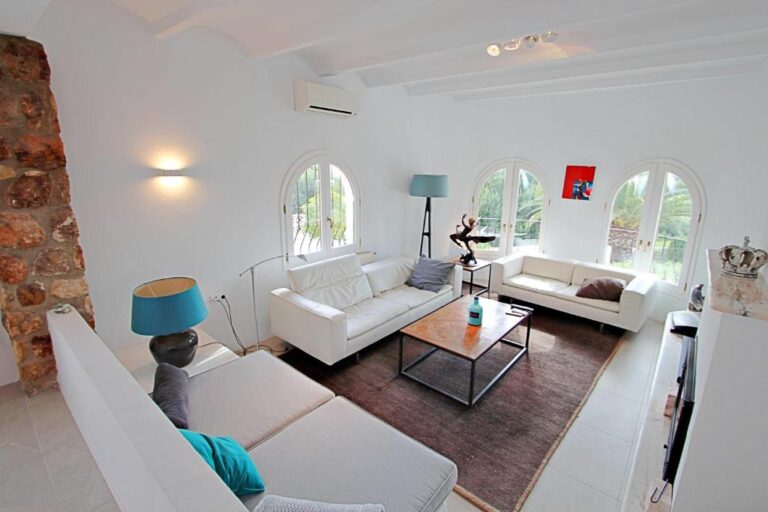 Living room with arched windows and exposed stone details at Moraira villa